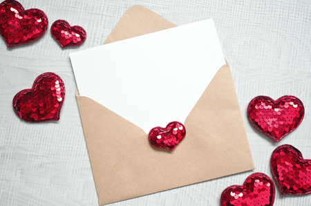 Blank white greeting card with brown envelop and hearts on marble table. Mockup valentines day conceptの写真素材