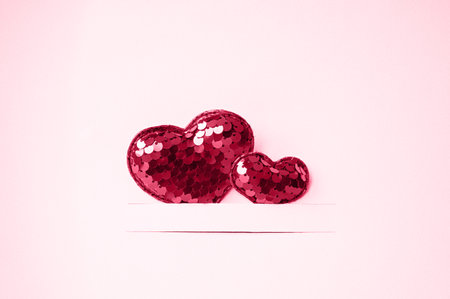 Two bright red hearts on a pink background with copy space. Valentine's day concept. Viva magenta color,の写真素材