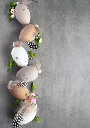 Collection of stylish colors eggs with flowers for Easter celebration on gray background. Holiday concept.の写真素材