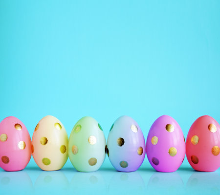 Collection of stylish colors eggs with golden circles for Easter celebration on blue background. Holiday concept.の写真素材
