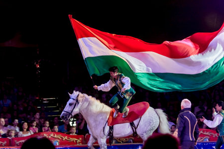 SZEGED, HUNGARY - JUNE 12. 2016 - horse riding performance of Hungarian National Circus by the Richter Group with a Hungarian flagのeditorial素材