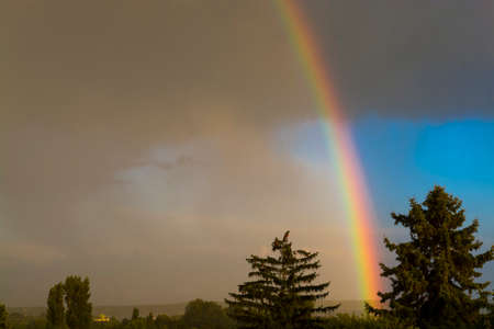 Rainbow in a rainy weather in the gray skyの写真素材