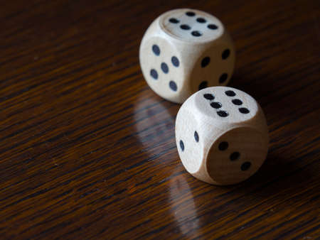 Rolling dice on a wooden table showing 12 pointsの写真素材