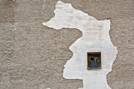 Small window and a great wall in an old houseの写真素材