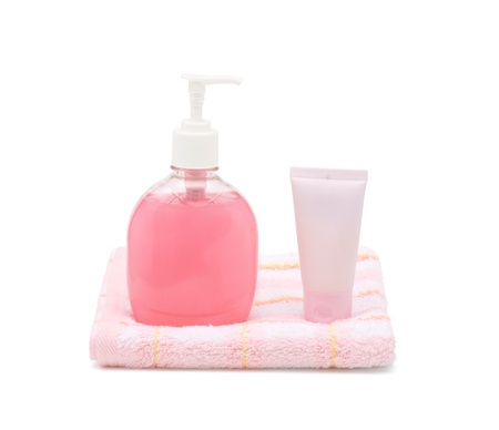 Liquid soap, cream tube and towel on white の写真素材