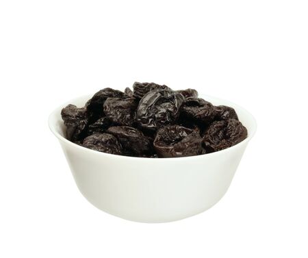 Dried plums or prunes  in a bowl isolated on white の写真素材