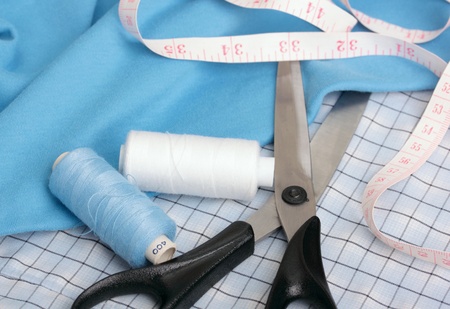 Sewing concept. Scissors, measuring tape, bobbin thread and fabric.の写真素材