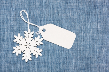 Blank paper label tag and snowflake on  blue jeansの写真素材