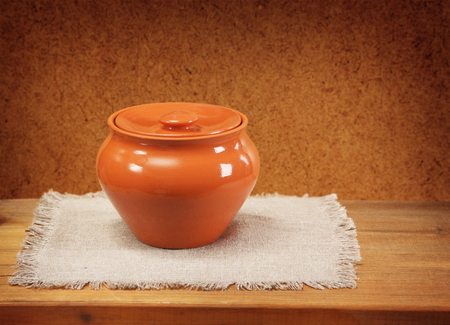 Clay pot for cooking and napkin on wooden table  Dark background の写真素材