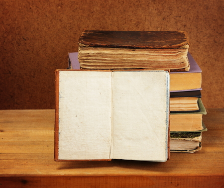 Books stack and opened book on wooden table  Dark background の写真素材