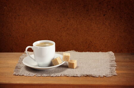 Coffee cup, saucer, sugar, napkin on wooden table  Dark background の写真素材