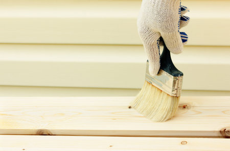 hand with paintbrush on woodの写真素材