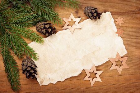 Christmas card: blank, Christmas tree branch, cone and decoration on woodの写真素材