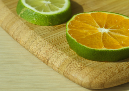 Slices of mandarine and lime on the cutting boardの写真素材