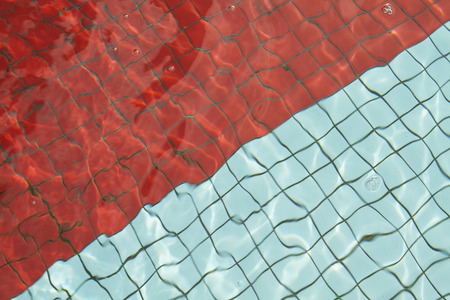 Swimminf pool floor with blue and red tilesの写真素材