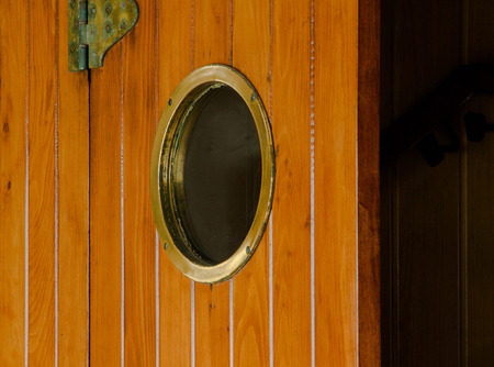 The old brown wooden  ship door with round windowの写真素材