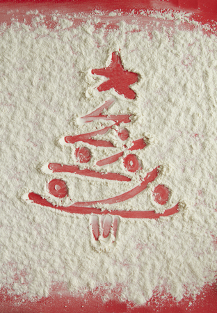 Red Christmas tree on flour background. White flour looks like snow. Top viewの写真素材