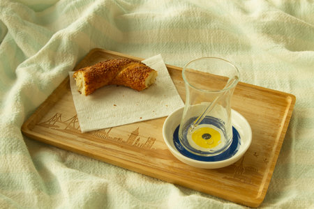 Finished breakfast it bad, empty glass from turkish tea and one  piece of bagel on napkin