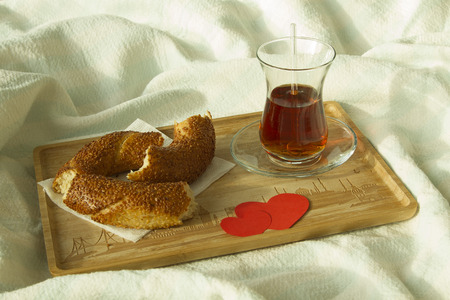 Morning turkish tea in traditional glass with bagel on the tray, breakfast in bedの写真素材