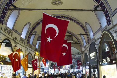 TURKEY, ISTANBUL - NOVEMBER 2016: People crowd and shops on the main street of Grand Bazaar with red turkish flags on 12 november 2016のeditorial素材