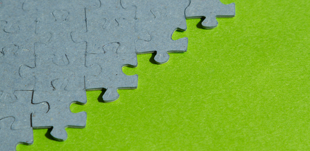 jigsaw puzzle pieces  on green background with copy spaceの写真素材