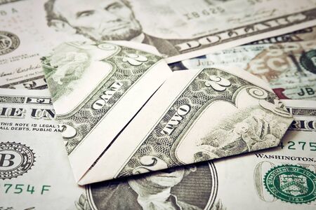 Dollar origami heart in banknotes background. Moneygami.の写真素材