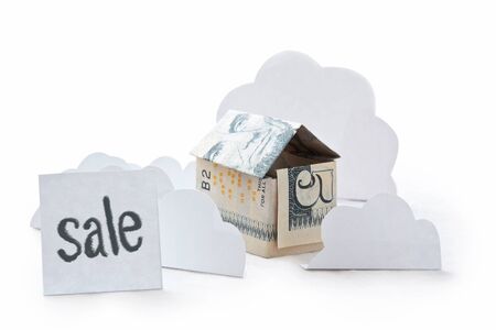 Small house made of dollar banknote isolated on white background. Inscription sale. Concept of real estate sale. Origami of money. Moneygami.の写真素材