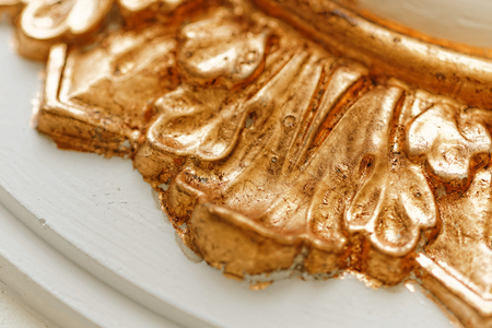 Close up of grunge golden potal texture. Foil on architectural detail. Cracelures and bitumen varnish. Selective macro focus.の写真素材