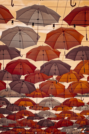 Multi-colored umbrellas in sky above the street. Alley floating umbrellas.の写真素材