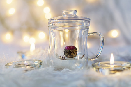 Green chinese tea flower bud blooming in glass tea cup on bokeh backgroundの写真素材