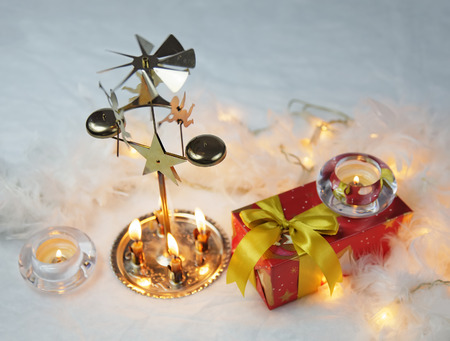 Close up of Xmas lantern with candles and gift. Christmas decoration on white fur. Shallow depth of field and bokehの写真素材