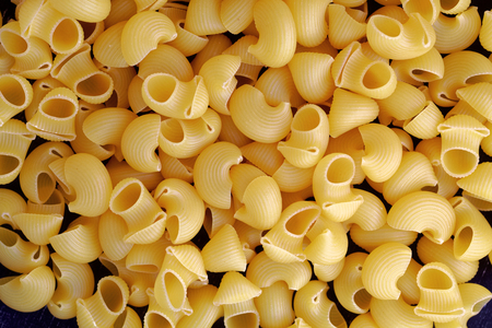 Close up of a raw dry Italian pasta horns on a black boardの写真素材
