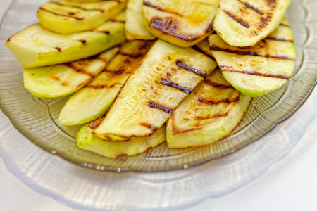 Close up grilled zucchini on plate. Macro of a vegetable. Shallow depth a fieldの写真素材