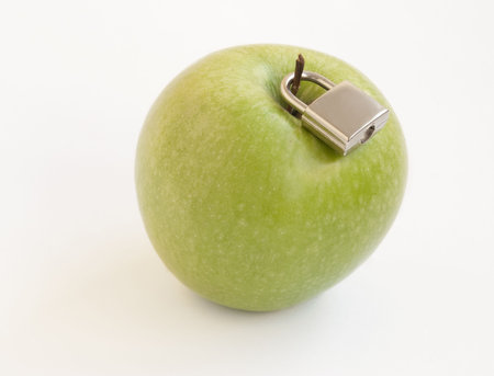 Green apple with metal padlock, concept