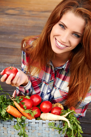 beautiful woman with vegetables in the gardenの写真素材