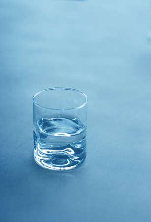 Glass of water sits on a tableの写真素材