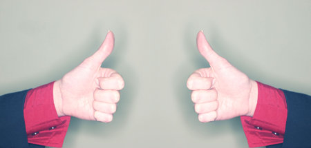 two identical woman give the thumbs upの写真素材