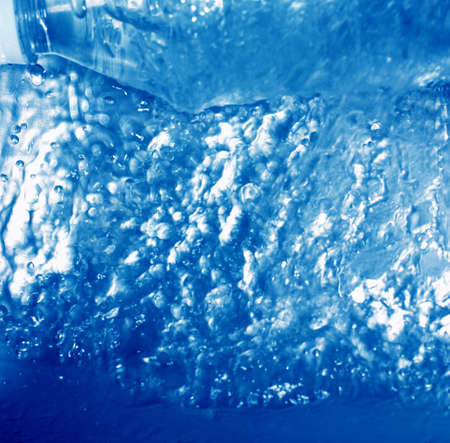 Water bottle is at the top of water rushing underneath itの写真素材