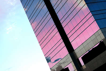Business building with glass exterior and blue and purple colors, just before sunsetの写真素材