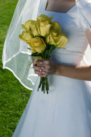 Beautiful bride's dress as bride is holding yellow bouquetの写真素材