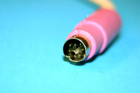 Pink computer plug-in against a blue backgroundの写真素材