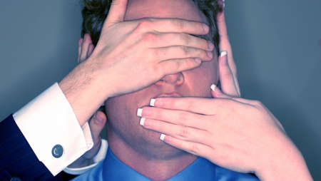 Businessman's eyes and mouth is being blocked by other business people.の写真素材