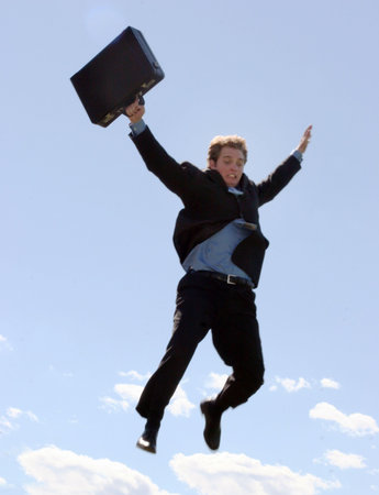 Businessman finally understands that success requires risks, and so he leaps as he holds onto his briefcaseの写真素材