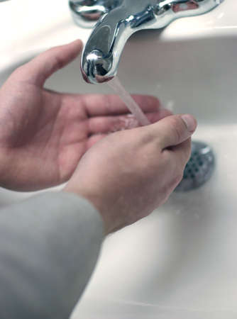 Man is washing hands in sinkの写真素材