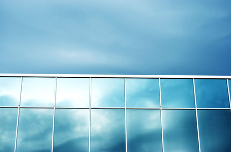 Glass business building with blue windows against blue sky