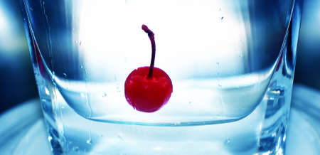 cool, red cherry floating in clean, pure refreshing waterの写真素材