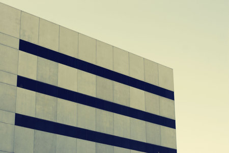 Darker tan business building with blue windows against tan background