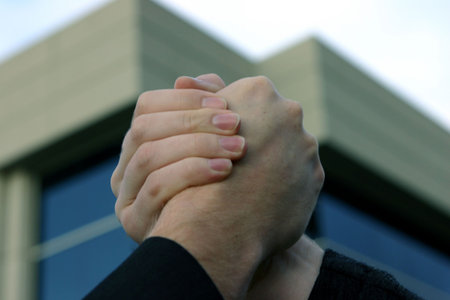 Business handshake in front of blue office building