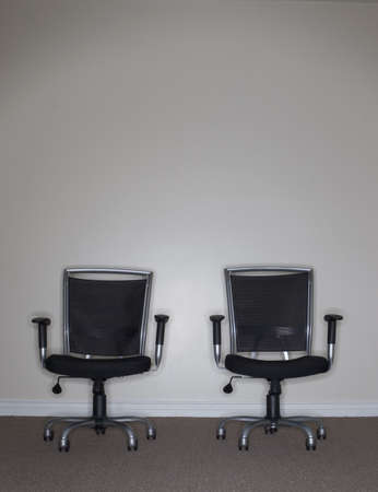 Twin Business Chairs sitting together and facing forward in an office roomの写真素材
