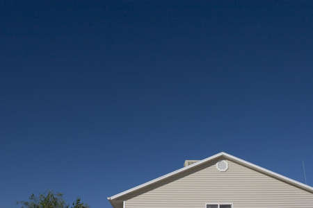 Top half of a Suburban home in America with a big blue skyの写真素材